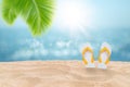 Tropical beautiful seascape view of sand beach with yellow sandals and blurred blue sky with bokeh sunlight in background. Royalty Free Stock Photo