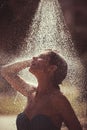 Summer vacation and travel. woman washing under water or rain drop. refreshment and hygiene on spa resort. Tropical