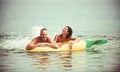 Summer vacation and travel to ocean. Couple in love sunbath on beach on air mattress. Pineapple inflatable mattress Royalty Free Stock Photo
