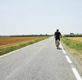 Summer vacation trip on bicycle - biker ride through gold agricultural field