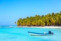 Summer vacation and tropical beach concept. Blue boat against sandy beach with palms and turquoise sea. Vacation island Royalty Free Stock Photo