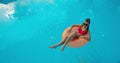 Summer Vacation Woman in bikini on inflatable mattress in swimming pool. Top view of girl relaxing sunbathing enjoying Royalty Free Stock Photo