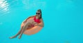 Summer Vacation Woman in bikini on inflatable mattress in swimming pool. Top view of girl relaxing sunbathing enjoying Royalty Free Stock Photo