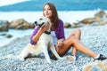 Summer vacation, woman with a dog on a walk on the beach Royalty Free Stock Photo