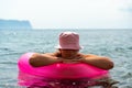 Summer vacation woman in hat floats on an inflatable donut mattress. Happy woman relaxing and enjoying summer travel Royalty Free Stock Photo