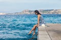 Beautiful woman relaxing on pier in Sardinia island, Italy Royalty Free Stock Photo
