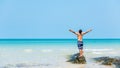 Summer vacations. Lifestyle man raise arm relax and chill on the rock, blue beach and sky background. Royalty Free Stock Photo