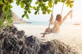 Summer Vacations.  Lifestyle women relaxing and enjoying swing on the sand beach, fashion stunning women on the tropical island so Royalty Free Stock Photo