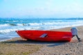 Summer Vacations. The red kayak is parked on the sandy beach on a sunny day, waiting for people to paddle out to sea. Royalty Free Stock Photo