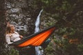 Summer vacations - woman chilling in hammock in forest travel outdoor tourist girl enjoying waterfall view in Norway Royalty Free Stock Photo