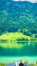 Summer view of the forest, Weissensee lake and part of the roof with a chimney Royalty Free Stock Photo