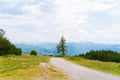 Summer View of mountain valley road in Alps. mountain peaks and Cable car station on the horizon. Dirt road and hiking Royalty Free Stock Photo