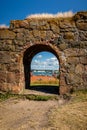 Summer view through an old medieval stone wall arched gate at Varberg Fortress in Sweden with the city and harbor in the backgroun Royalty Free Stock Photo