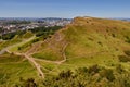 Summer view of Salisbury Crags from Arthur`s Seat in Holyrood Park with beautiful green grass and blue sky in Edinburgh, Scotland. Royalty Free Stock Photo