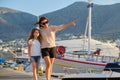 Summer walks on sea pier, mother and daughter child walking together holding hands Royalty Free Stock Photo