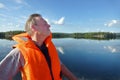 Summer water landscape. Blue sky and clear water of Lake Pyaozero with reflected clouds. A man in life jacket manages motor boat a Royalty Free Stock Photo