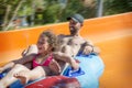 In the summer, in a water park, a girl and dad ride down the hill on an air mattress Royalty Free Stock Photo