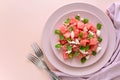 Summer watermelon salad with feta cheese, sesame seeds and mint leaves on pink plate. Royalty Free Stock Photo