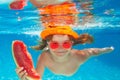 Summer watermelon. Young boy swim and dive underwater. Under water portrait in swim pool. Child boy diving into a Royalty Free Stock Photo