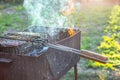 Summer Weekend BBQ Scene On The Backyard. Flaming Charcoal Grill. Grill with fire in nature in the evening Royalty Free Stock Photo