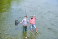 Summer weekend. Fishing together. Men stand in water. Nice catch concept. Fishing team. Happy fisherman with fishing rod