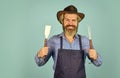 summer weekend. happy hipster hold cooking utensils for barbecue. bearded man chef. Tools for roasting meat outdoors Royalty Free Stock Photo