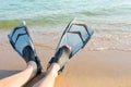 Summer wellness holidays by the sea concept, feet in fins on the beach Royalty Free Stock Photo