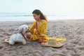 Summer. Woman With Dog On Beach. Fashion Girl In Maxi Yellow Boho Dress Enjoying Vacation At Tropical Ocean