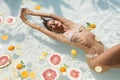 Summer Woman Floating At Pool With Citrus. Beautiful Model In Bikini Enjoying Sunny Day At SPA. Royalty Free Stock Photo