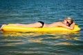 Summer woman floating on yellow water mattress Royalty Free Stock Photo