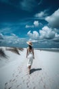 Summer woman in hat walking away in white sand , blue sky. Ai generative