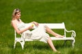 Summer - Woman sitting on bench in meadow Royalty Free Stock Photo