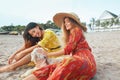 Summer. Women With Dog On Beach. Fashion Girls In Maxi Boho Dresses And Straw Hat Enjoying Vacation With Pet