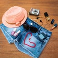 Summer women's accessories: red sunglasses, beads, denim shorts, mobile phone, headphones, a sun hat, camera, nail polish, Royalty Free Stock Photo