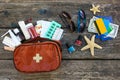 Summer women`s beach accessories for your sea holiday and first aid kit on old wooden background. Royalty Free Stock Photo