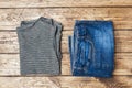 Summer women`s clothes. Flat lay fashion photo. Grey striped t-shirt and blue jeans on wooden background