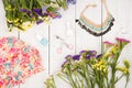 summer women set with dress, colorful flowers, cosmetics makeup, bijou and essentials on white wooden background Royalty Free Stock Photo