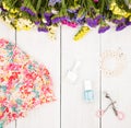 summer women set with dress, colorful flowers, cosmetics makeup, bijou and essentials on white wooden background Royalty Free Stock Photo