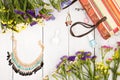 summer women set with straw bag, colorful flowers, cosmetics makeup, bijou and essentials on white wooden background Royalty Free Stock Photo