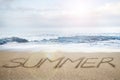 Summer word written on sand beach with sky clouds sunlight Royalty Free Stock Photo