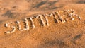 Summer. A word written by small pebbles on a sandy beach Royalty Free Stock Photo