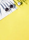 Summer yellow cosmetics flat lay with sunglasses . Top view beauty composition.