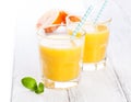 Summer yellow orange lemonade in glass with blood oranges and straw on a wooden table Royalty Free Stock Photo