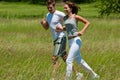 Summer - Young couple jogging in a meadow Royalty Free Stock Photo