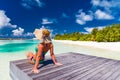 Perfect beach vacation for summer travel background. Relaxed woman wearing sun hat and bikini on a palm trees with the blue sea Royalty Free Stock Photo