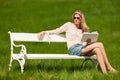 Summer - Young woman sitting on bench in meadow Royalty Free Stock Photo