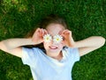 Summertime bliss. a little girl covering her eyes with flowers while playing outside. Royalty Free Stock Photo