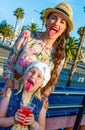 Mother and child travellers showing tongues after drinking