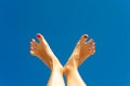 Summertime enjoyment. Woman feet on blue sky background.