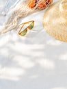 Beach accessories, exotic fruit and a bottle of water on the white background.